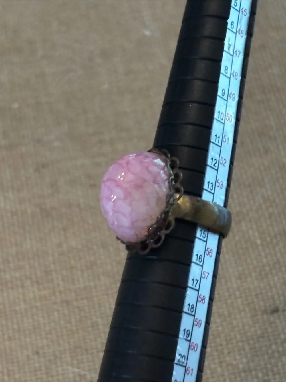 Pink cabochon stone set in an ornate, antiqued brass filigree setting Adjustable